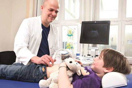Arzt untersucht ein Kind mit Ultraschall